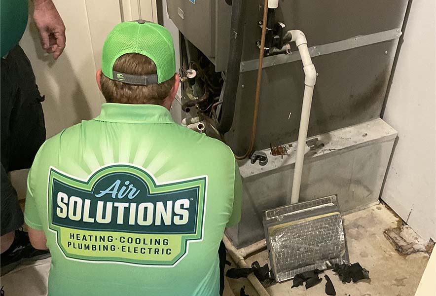 Air Solution technician performing furnace maintenance