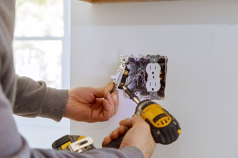 Electrician performing outlet installation